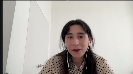 A Zoom video tile of guest speaker Ceren Topcu speaking during class, wearing a polka-dot top with wired earbuds.